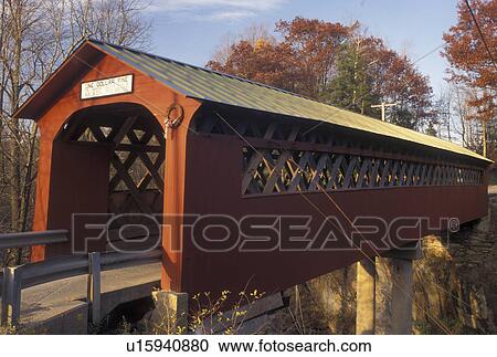 Stock Image -  covered bridge, fall, Vermont, The red Chiselville Covered Bridge c. 1870 spans across the river in Arlington in Bennington County in the state of Vermont during the autumn season.. Fotosearch