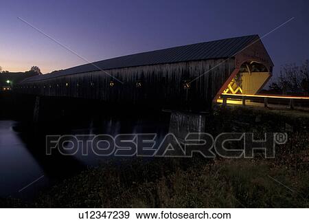 covered bridge, fall, wooden bridge, Vermont, New Hampshire, Connecticut River, Lights from a car streak through The Windsor-Cornish Covered Bridge c. 1866 at night which spans the Connecticut River connecting the states of Vermont and New Hampshire. It i View Large Photo Image Stock Photo - covered bridge, fall, wooden bridge, Vermont, New Hampshire, Connecticut River, Lights from a car streak through The Windsor-Cornish Covered Bridge c. 1866 at night which spans the Connecticut River connecting the states of Vermont and New Hampshire. It i. Fotosearch