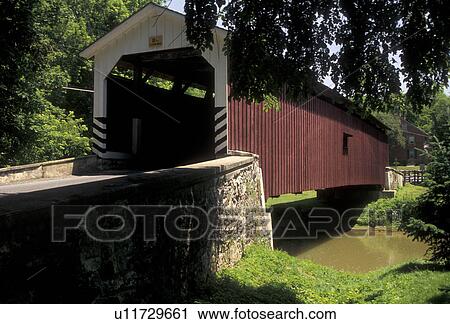 Stock Image -  covered bridge, Lancaster County, Strasburg, Amish Country, Pennsylvania, Red wooden covered bridge in scenic Pennsylvania Dutch Country in Lancaster County in the state of Pennsylvania.. Fotosearch
