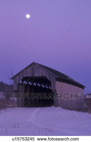Stock Photography -  covered bridge, Vermont, VT, Full moon rises over a covered bridge and a snow-covered field in the evening in the town of Cambridge in winter.. Fotosearch