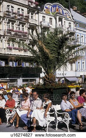 Stock Photo -  Czech Republic, Karlovy Vary, spa, Europe, People sitting on benches in the plaza enjoying a sunny day in Karlovy Vary.. Fotosearch