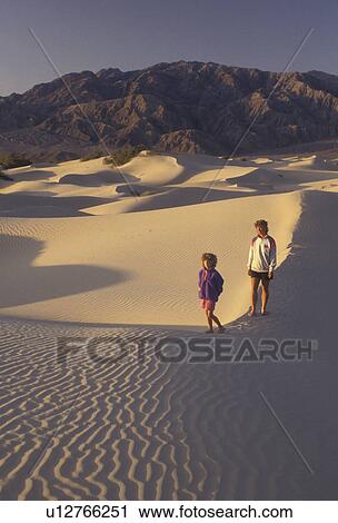 Death Valley, sand dunes, Death Valley National Park, Mojave Desert, California, Mother and daughter (6 years old) walk on the sand dunes in the early morning light with the Panamint Mountains in the distance in Death Valley Nat'l Park in the state of Ca View Large Photo Image Stock Image - Death Valley, sand dunes, Death Valley National Park, Mojave Desert, California, Mother and daughter (6 years old) walk on the sand dunes in the early morning light with the Panamint Mountains in the distance in Death Valley Nat'l Park in the state of Ca. Fotosearch