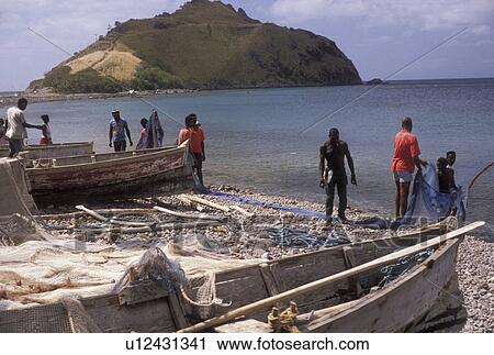 Dominica, Caribbean, Caribbean Islands, Local fishermen working with fishing nets on the beach at Scotts Head on the island of Dominica. View Large Photo Image Stock Image - Dominica, Caribbean, Caribbean Islands, Local fishermen working with fishing nets on the beach at Scotts Head on the island of Dominica.. Fotosearch
