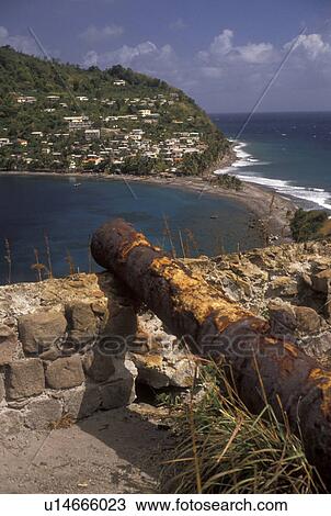 Stock Image -  Dominica, Caribbean, Caribbean Islands, fort, Old cannon on overlook at Scotts Head on the island of Dominica.. Fotosearch