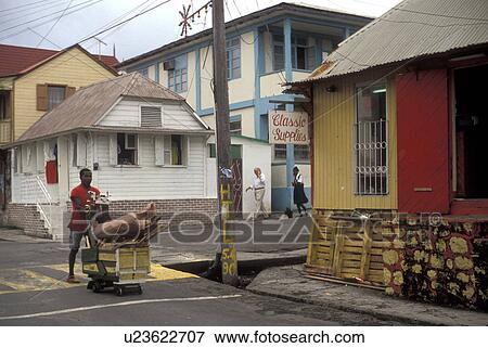 Dominica, Caribbean, Roseau, Caribbean Islands, Local man pushing cart on the street through downtown Roseau the capital of the island of Dominica. View Large Photo Image Stock Photo - Dominica, Caribbean, Roseau, Caribbean Islands, Local man pushing cart on the street through downtown Roseau the capital of the island of Dominica.. Fotosearch