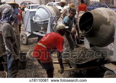 Stock Image -  Dominica, Caribbean, Roseau, industrial, Caribbean Islands, Construction workers paving in downtown Roseau the capital of the island of Dominica.. Fotosearch