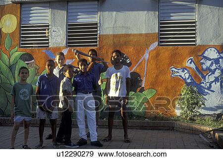Stock Photo -  Dominican Republic, Santo Domingo, Caribbean, Caribbean Islands, Boys posing in front of a building with a baseball mural painted on it in Santo Domingo in the Dominican Republic.. Fotosearch