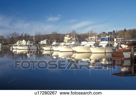 Stock Photo -  Essex, Connecticut, marina, Boats moored at the dock reflect in the calm waters of the Connecticut River in Essex, Connecticut.. Fotosearch