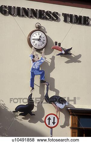 Stock Photo -  Europe, Republic of Ireland, Ireland, beer, Guinness (beer) Time Sign, clock, pub sign. . Fotosearch