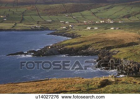 Stock Photograph -  Europe, Republic of Ireland, Ireland, Ring of Kerry, Iveragh, Scenic view of the lush green pastures and beautiful coast line in Ballynahow on the Atlantic Ocean in County Kerry.. Fotosearch