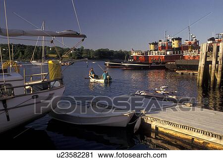 Stock Image -  fireboat, Maine, harbor, port, Atlantic Ocean, Sailboat and fireboats moored at the docks on the harbor in Belfast in the state of Maine.. Fotosearch