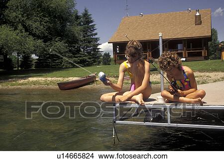 fishing, girls, summer camp, Alexandria, Minnesota, Two young girls in bathing suits sitting quietly fish off the end of a dock in front of a log cabin on Maple Lake in Alexandria in the state of Minnesota. View Large Photo Image Picture - fishing, girls, summer camp, Alexandria, Minnesota, Two young girls in bathing suits sitting quietly fish off the end of a dock in front of a log cabin on Maple Lake in Alexandria in the state of Minnesota.. Fotosearch