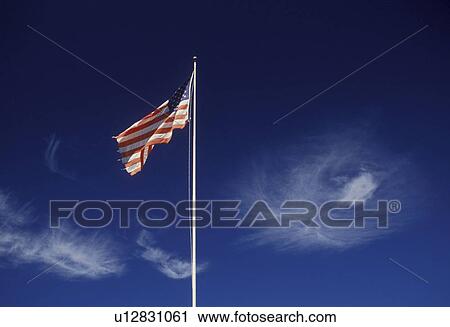 Stock Image -  flag, sky, clouds, Vermont, The American flag flys against wispy clouds and a clear blue sky. . Fotosearch