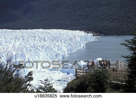 Stock Photography -  glaciers, Patagonia, Argentina, Andes, People on observation deck watching the Moreno Glacier which rises 60 meters above lake level in Parque Nacional de los Glaciares (National Park) in Patagonia. . Fotosearch