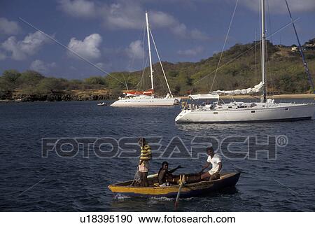 Grenadine Islands, Caribbean, Mayreau, Caribbean Islands, Local fishermen row their boat next to white sailboats in Saline Bay on the island of Mayreau in the St. Vincent Grenadines (a British Commonwealth member). View Large Photo Image Stock Image - Grenadine Islands, Caribbean, Mayreau, Caribbean Islands, Local fishermen row their boat next to white sailboats in Saline Bay on the island of Mayreau in the St. Vincent Grenadines (a British Commonwealth member).. Fotosearch