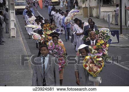 Stock Image -  Guadeloupe, Caribbean, Caribbean Islands, Funeral procession on Main Street in Gosier on the island of Basse-Terre in Guadeloupe (a french department) The Emerald Isle.. Fotosearch