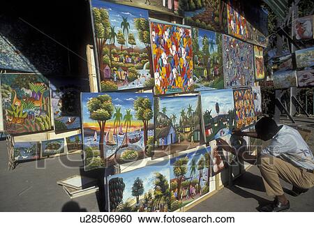 Stock Image -  Haiti, Caribbean, Haitian street artist displays his naive paintings on the street in the city of Port-Au-Prince capital of Haiti . Fotosearch