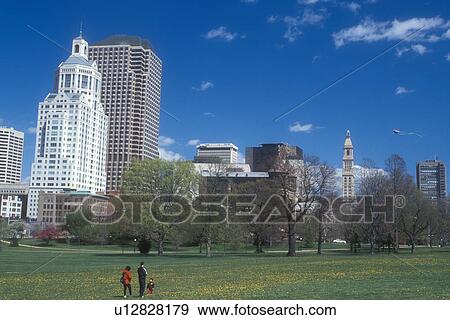 Stock Photo -  Hartford, skyline, Bushnell Park, Connecticut, The downtown skyline of the capital city of Hartford, Connecticut from Bushnell Park in the spring. Family flying a kite in the park.. Fotosearch