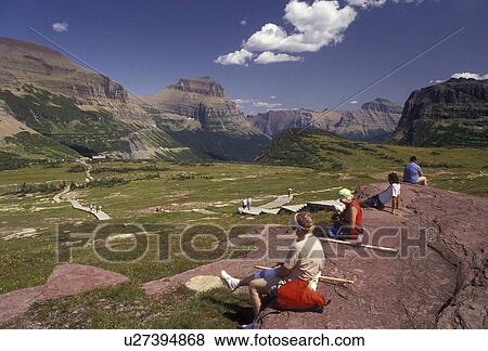 hiking, Glacier National Park, Montana, Rocky Mountains, Waterton-Glacier International Peace Park, Hikers take a break near Logan Pass taking in the spectacular view of the mountains in Glacier National Park in the state of Montana. View Large Photo Image Stock Photo - hiking, Glacier National Park, Montana, Rocky Mountains, Waterton-Glacier International Peace Park, Hikers take a break near Logan Pass taking in the spectacular view of the mountains in Glacier National Park in the state of Montana.. Fotosearch