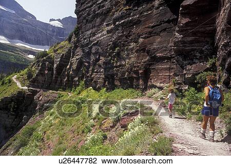 Stock Image -  hiking, Glacier National Park, trail, Montana, Rocky Mountains, Waterton-Glacier International Peace Park, Mother and 6 year old daughter hike the Grinnell Lake Trail in scenic Glacier National Park in the state of Montana.. Fotosearch