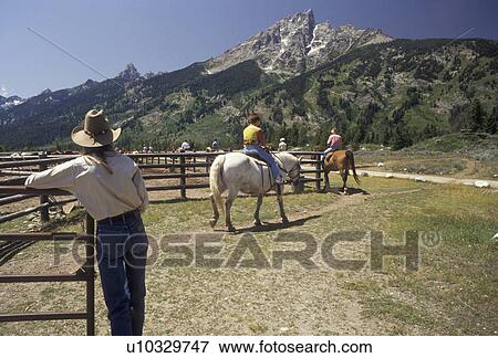 Stock Photo -  horseback riding, trail ride, Grand Teton National Park, Wyoming, Grand Teton, Rocky Mountains, Grand Teton Mountains, Teton Range, A group of people riding horses leave the corral at Colter Bay Village for the Teton Trail Ride through the Grand Teton Na. Fotosearch