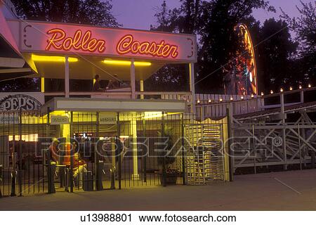 Stock Image -  Iowa, Arnold Park, Roller coaster ride at Arnold Park in the evening, the Oldest Amusement Park West of the Mississippi River. Fotosearch