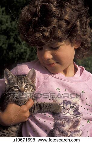 kitten, cat, child, girl, A young 5 year old girl sits holding a cute tiger striped kitten (5-6 weeks old) which matches the kitten on her pink sweatshirt in Exton in the state of Pennsylvania. View Large Photo Image Stock Photo - kitten, cat, child, girl, A young 5 year old girl sits holding a cute tiger striped kitten (5-6 weeks old) which matches the kitten on her pink sweatshirt in Exton in the state of Pennsylvania. . Fotosearch
