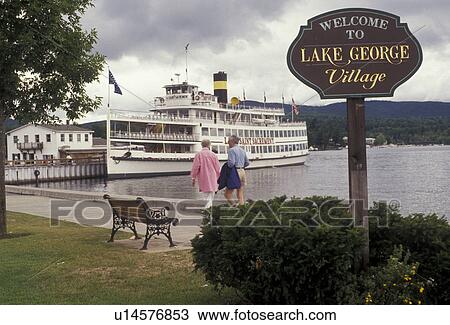 Stock Image -  Lake George, waterfront, steamboat, Adirondack Park, Adirondacks, adirondack, New York, Lac du Saint Sacrement excursion boat docked on Lake George waterfront in the village of Lake George in the state of New York. Welcome to Lake George sign at the wate. Fotosearch