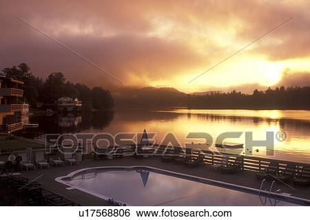 Stock Photograph -  Lake Placid, Adirondacks, Adirondack Park, New York, A scenic view of[sunrise, sunset, morning, evening] from the swimming pool at the Hilton Resort on Mirror Lake in Lake Placid in the state of New York. . Fotosearch