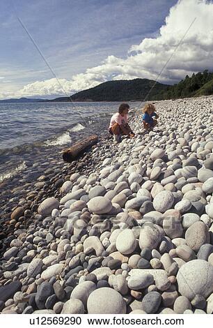Stock Image -  Lake Superior, rocky beach, Ontario, Canada, Mother and daughter looking at round rocks made by erosion on Pebble Beach in Marathon on Lake Superior in the Province of Ontario, Canada.. Fotosearch