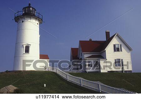 Picture -  lighthouse, Cape Cod, Falmouth, Massachusetts, The white Nobska Lighthouse sits on the hill. A white picket fence stretches along the lawn.. Fotosearch