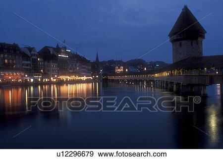 Stock Photo -  Lucerne, covered bridge, Switzerland, Luzern, Europe, The 14th century covered pedestrian bridge, the Kapellbrucke, on the Reuss in the evening in Lucerne is a picturesque landmark in the Canton of Lucerne. The octagonal stone tower alongside is called t. Fotosearch