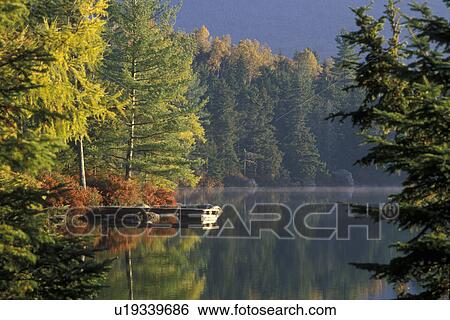Maine, fall, lake, reflection, Baxter State Park, The early morning sun shines on the calm water of Daicey Pond in Baxter State Park in the fall. A dock and the colorful fall foliage reflect in the quiet water. View Large Photo Image Stock Photograph - Maine, fall, lake, reflection, Baxter State Park, The early morning sun shines on the calm water of Daicey Pond in Baxter State Park in the fall. A dock and the colorful fall foliage reflect in the quiet water.. Fotosearch