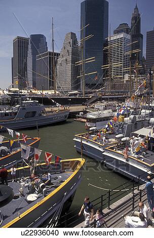 Stock Image -  Manhattan, South Street Seaport, New York City, N. Y. C navy, skyline, New York, NYC, Navy cadet fleet docked at South Street Seaport in Manhattan on the East River in New York City in the state of New York. Manhattan skyline in the background.. Fotosearch