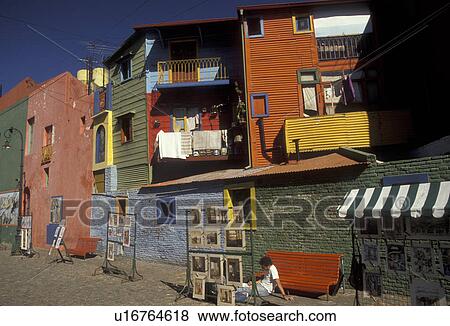 Stock Photo -  market, Buenos Aires, Argentina, Local artist's display their work at an artist market in the district of La Boca in the capital city of Buenos Aires. Laundry hanging from colorful houses in the background.. Fotosearch