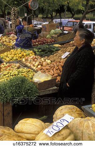 Stock Image -  market, Chile, Valdivia, Local elderly woman selling fresh produce at an outdoor market in Valdivia in the South-Central Region in Chile. Person weighing fruit on a scale at the market.. Fotosearch