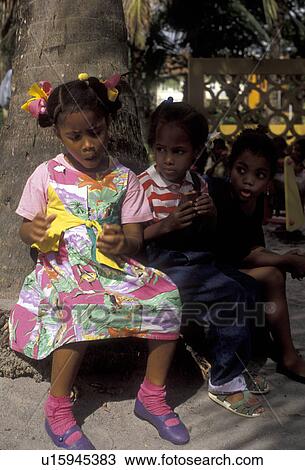 Martinique, Caribbean, Caribbean Islands, Three young girls sitting in the shade eating a snack in Fort-de-France the capital of the island of Martinique (a french department). View Large Photo Image Stock Image - Martinique, Caribbean, Caribbean Islands, Three young girls sitting in the shade eating a snack in Fort-de-France the capital of the island of Martinique (a french department).. Fotosearch