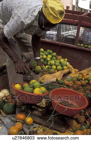 Stock Image -  Martinique, Caribbean, Caribbean Islands, citrus, market, Local black man selling oranges from the back of his truck in Le Marin on the island of Martinique (a french department).. Fotosearch