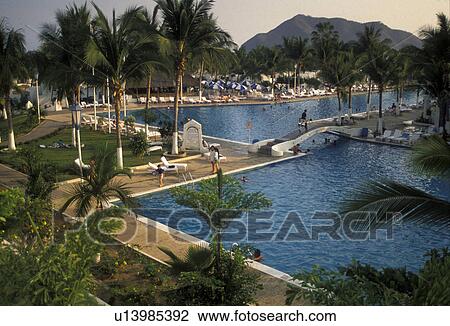 Mexico, Manzanillo, resort, People enjoying the huge swimming pool at the sea resort in Manzanillo in the state of Colima. View Large Photo Image Stock Image - Mexico, Manzanillo, resort, People enjoying the huge swimming pool at the sea resort in Manzanillo in the state of Colima. . Fotosearch