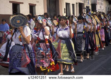 Stock Image -  Mexico, people, Patzcuaro, Mexican women wearing colorful clothes walking in a church parade in the city of Patzcuaro in the state of Michoacan.. Fotosearch
