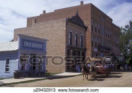 Stock Image -  Michigan, Flint, A carriage ride pulled by a team of mules takes visitors through the restored town at the Crossroads Village & Huckleberry Railroad in Flint . Fotosearch