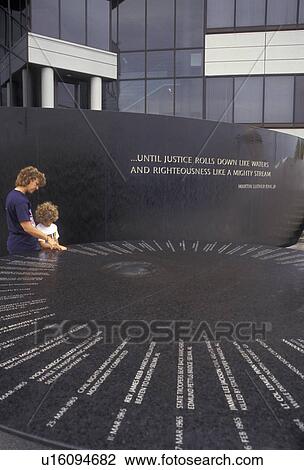 Stock Image -  Montgomery, Alabama, civil rights, Mother and daughter (7 years old) looking at the inscriptions on the Civil Rights Memorial in Montgomery in the state of Alabama.. Fotosearch