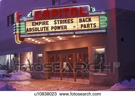 Stock Image -  movie theater, neon lights, Vermont, VT, Capitol Movie Theater illuminated at night in downtown Montpelier in the snow in winter.. Fotosearch
