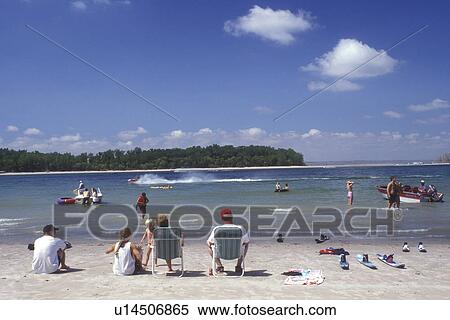 Nebraska, Family sitting on the beach watching people enjoying Lake McConaughy at Lake McConaughy Recreation Area. View Large Photo Image Stock Photography - Nebraska, Family sitting on the beach watching people enjoying Lake McConaughy at Lake McConaughy Recreation Area.. Fotosearch