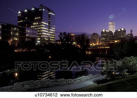Stock Image -  Nebraska, The skyline of downtown Omaha in the evening from the Gene Leahy Mall.. Fotosearch