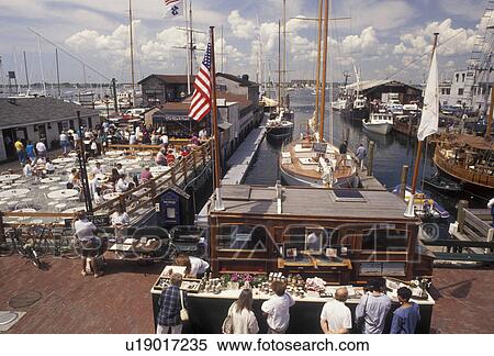 Stock Photography -  Newport, Newport Harbor, Rhode Island, People enjoying a sunny day on Sayer's Wharf in The Mooring at Newport's colonial seaport in the state of Rhode Island. . Fotosearch