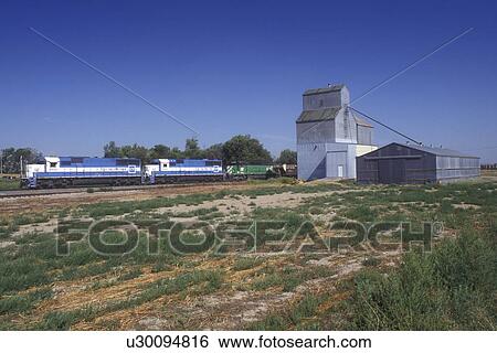 Stock Photograph -  North Dakota, A train collecting grain from a grain elevator in Dore.. Fotosearch