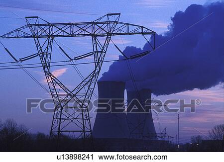 Stock Image -  nuclear power plant, powers lines, Pennsylvania, steam rises from the cooling towers of the Philadelphia Electric Co. nuclear power plant next to power lines in Limerick in the evening.. Fotosearch