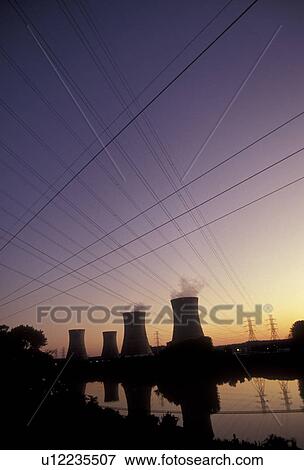 Stock Photo -  nuclear, Three Mile Island, electricity, nuclear power plant, Pennsylvania, Silhouette of Three Mile Island Nuclear Power Plant cooling towers reflecting in the calm water of the Susquehanna River at sunset in Middletown in the state of Pennsylvania. Sit. Fotosearch