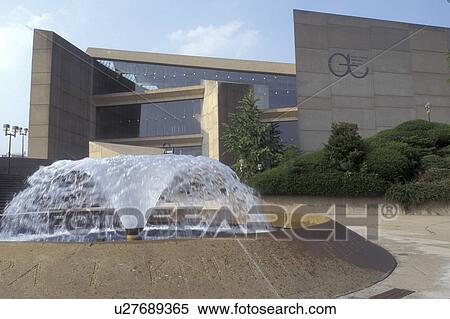 Stock Photography -  Ohio, Akron, A water fountain splashes in front of a building at the University of Akron campus . Fotosearch